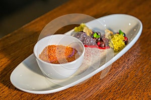 Creme brulee with hot forest fruit served on white plate in modern restaurant, product photography for gastronomy