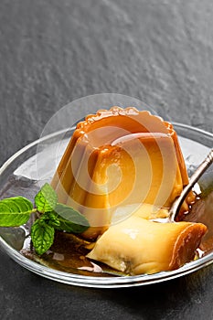 Creme caramel custard pudding on black stone background