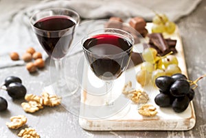 Creme de Cassis homemade liqueur served with grapes, nuts and chocolate. Rustic style