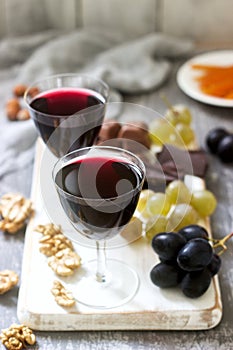 Creme de Cassis homemade liqueur served with grapes, nuts and chocolate. Rustic style.