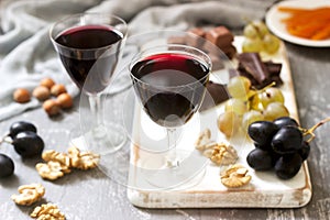 Creme de Cassis homemade liqueur served with grapes, nuts and chocolate. Rustic style.