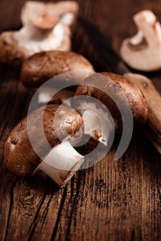 Cremini mushrooms on textured wood background. Baby portobello. Closeup. Selective focus