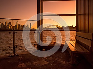 Cremorne Point Wharf at the waterfront with beautiful Sydney harbor sunset scenery in the background.
