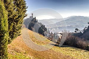 Crenellated Clock tower on overlooking hills in the fog photo