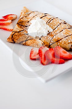 Crepe with fresh strawberries sprinkled with sugar