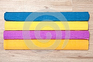 Four multicolored rolls of corrugated paper lie on board.