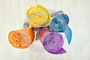 Crepe wrapping paper is twisted into four colored rolls.