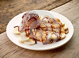 Crepes with banana and chocolat icecream on wooden desk