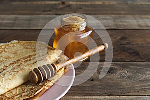 Crepes with honey on a wooden background. Copy space