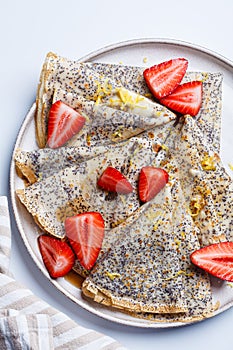 Crepes with poppy seeds, maple syrup and strawberries