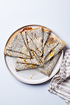 Crepes with poppy seeds, maple syrup and zest