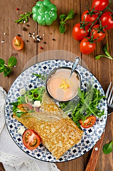 Crepes stuffed with salami, tomatoes, lettuce, mozzarella and cheese sauce