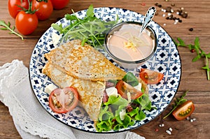 Crepes stuffed with salami, tomatoes, lettuce, mozzarella and cheese sauce