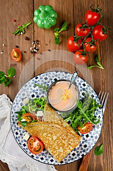 Crepes stuffed with salami, tomatoes, lettuce, mozzarella and cheese sauce