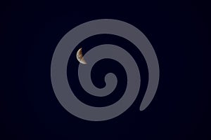 The crescent moon is in the night sky