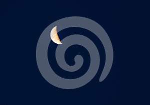 The crescent moon is in the night sky