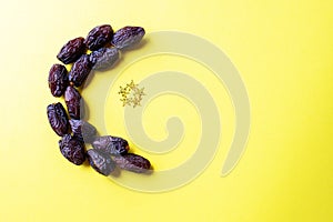 Crescent moon shape from medjoul dates on a yellow background