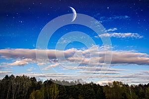 Crescent in the night sky, clouds and stars