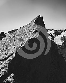 The crest of a rock against the backdrop of a mountain landscape at dawn B&W