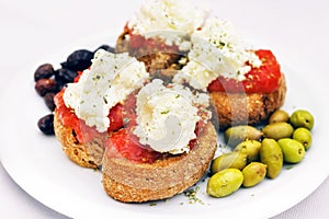 Cretan appetizer - dakos, rusk with tomato sauce, olives and local staka cheese