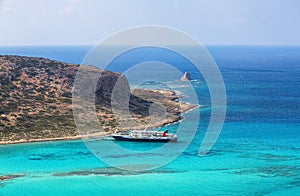 Crete coast, Balos bay, Greece. The ship is going on the marvelous turquoise sea. Popular touristic resort. Summer landscape.