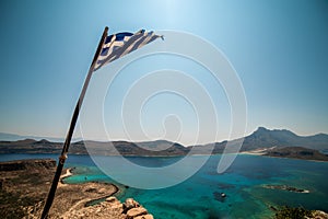 Crete, Greece: Greek flag over Gramvousa island and Balos Lagoon