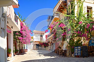 CRETE ISLAND, GREECE, SEP 06, 2012: View on Panormo small city street with bakery restaurant cafe red flowers small hotel for tour