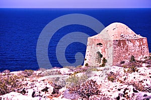 Crete or Kreta, Greece - September 15, 2017: Ruin of ottoman building on Gramvousa on venetian fort against deep blue sea, Wide