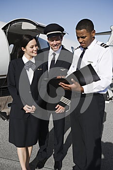 Crew Members Discussing Reports At Airfield