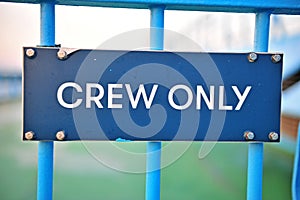 Crew only sign on blue fence