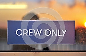 Crew only sign with sunset on background