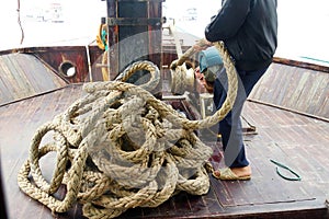 Crewman hauling in the anchor