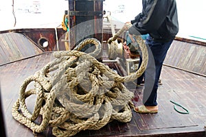 Crewman hauling in the anchor