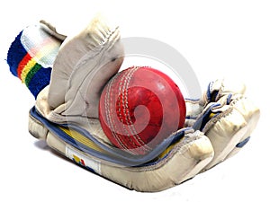 Cricket glove holding red ball