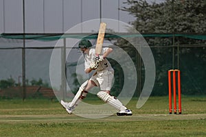 Cricket school boy is attacking the ball