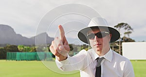 Cricket umpire making signs standing on a cricket pitch