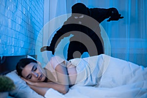 Thief ready to attack woman who is sleeping in bed