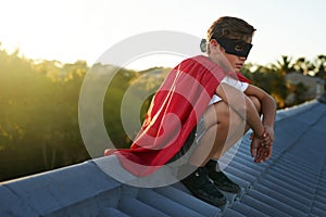 Crime never sleeps and neither does he. a young boy in a cape and mask playing superhero outside.