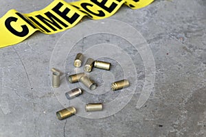Crime scene concept with a gun, crime scene tape and bullet casings photo