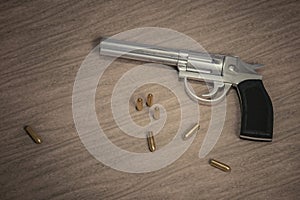 Crime scene. Gun with many bullets on wooden background. 3D rendered illustration
