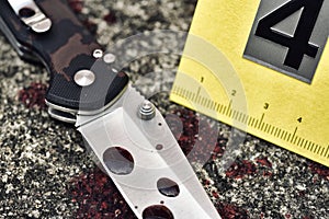 Crime scene investigation, Bloody knife and victim`s shoes with criminal markers on ground, Homicide evidence.