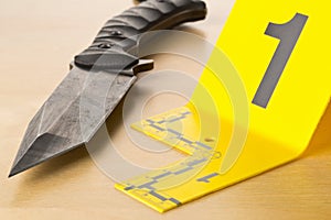 Crime scene investigation CSI evidence marker with knife on wood floor background at crime scene - police, evidence or forensic