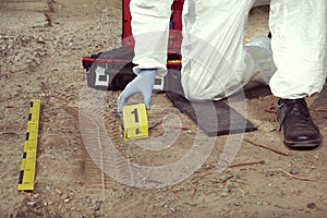 Technician Criminologist preparing tire print left in dust of field way for documentation