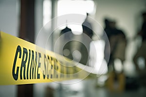 crime scene tape with blurred forensic law enforcement background in cinematic tone