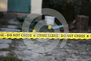 Crime scene tape for covering the area cordon. Yellow tape with blurred forensic law enforcement background in cinematic tone