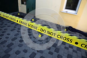 Crime scene tape for covering the area cordon. Yellow tape with blurred forensic law enforcement background in cinematic tone