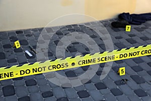 Crime scene tape for covering the area cordon. Yellow tape with blurred forensic law enforcement background in cinematic tone