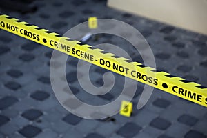 Crime scene tape for covering the area cordon. Yellow tape with blurred forensic law enforcement background in cinematic tone