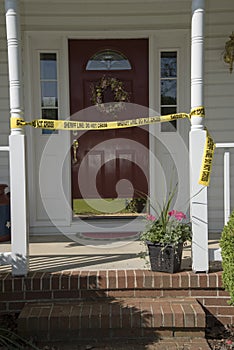 Crime scene tape at entrance to a residence