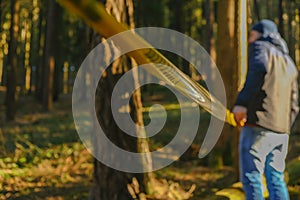 Crime scene. Yellow protective tape in a pine forest.Man fencing crime scene with yellow tape.Signs and symbols